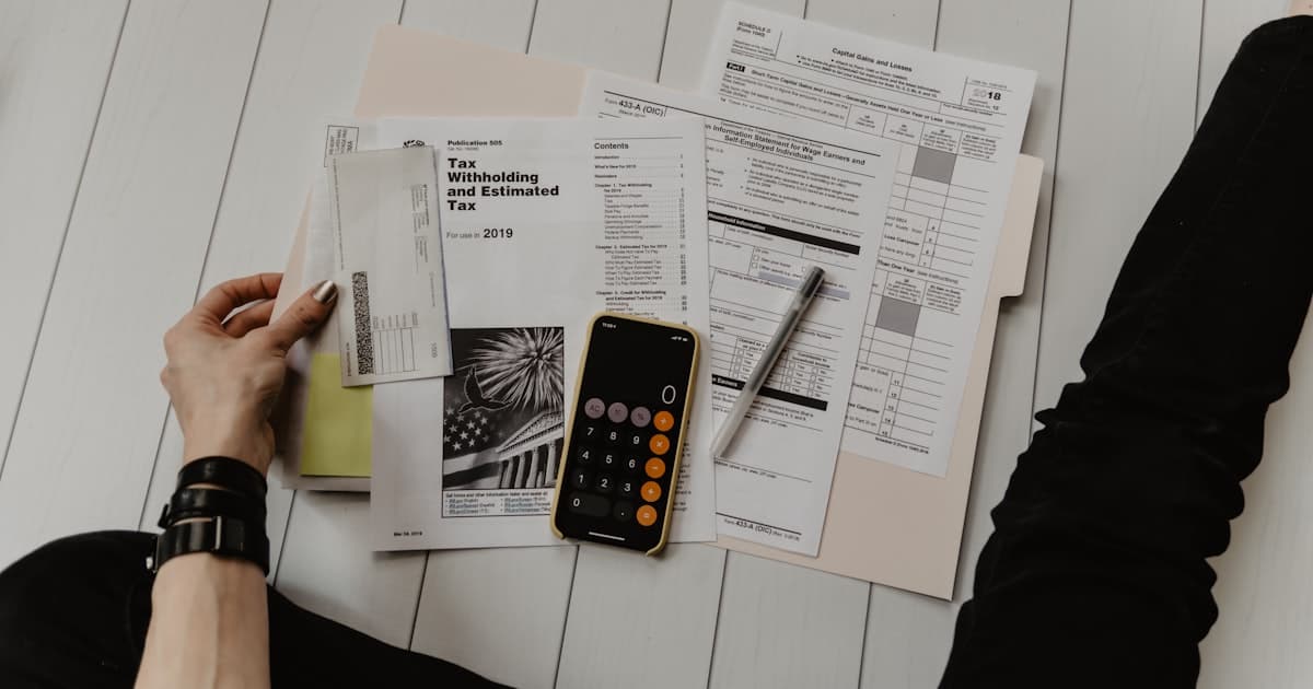 A federal budget planning document and investment portfolio dashboard on a desk in a government office